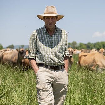 A farmer in front of grazing cattle