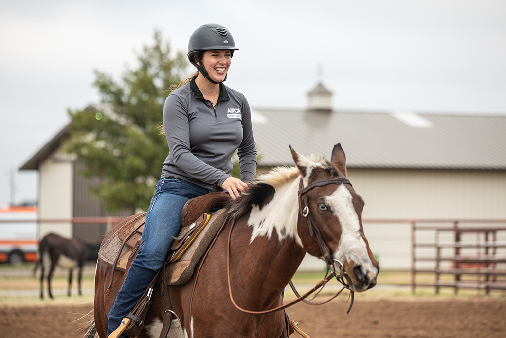 a woman riding a brown and white horse