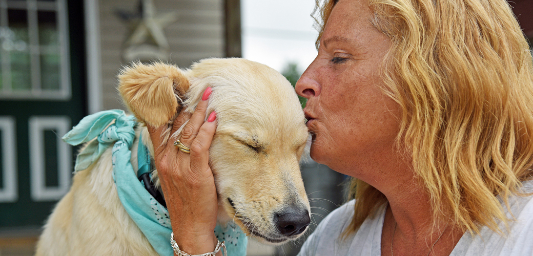 a woman kissing her dog