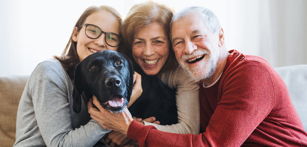 Family hugging dog